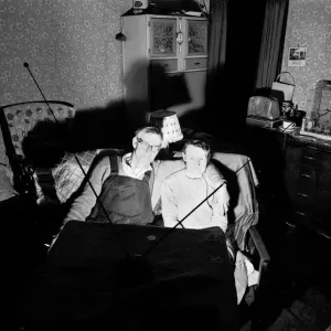 A 1959 Print of a Husband and Wife Watching a Coin-Operated Television Set