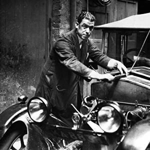 Everton footballer William "Dixie"Dean dressed in mechanic overalls as he goes