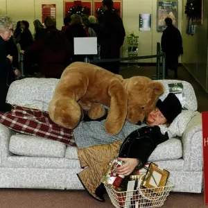 Ewan MacLeod Print: Lying on Sofa with Giant Teddy Bear and Christmas Shopping Ewan MacLeod Print: Lying on Sofa with Giant Teddy Bear and Christmas Shopping
