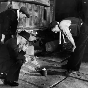 An expert makes a closer examination of a sample of steel taken from a 30 ton Electric An expert makes a closer examination of a sample of steel taken from a 30 ton Electric