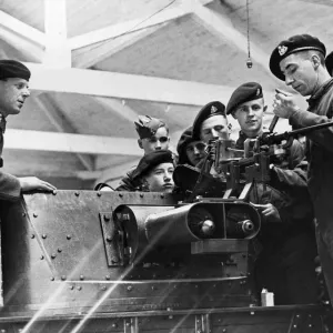 An explanation of the details of an anti-tank gun being given to members of a West