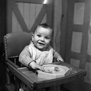 Expressions. An 11 month old child smiling with his food. January 1950