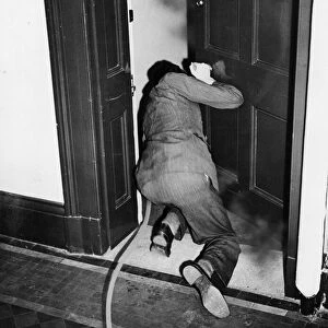 How to extinguish a fire bomb. A man crouches in the doorway of a smoke filled room