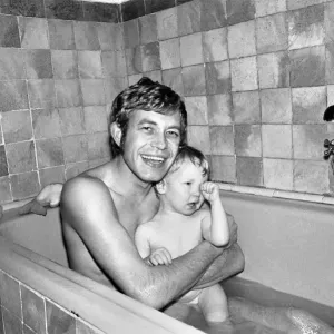 Print of a family scene featuring a father bathing with two children
