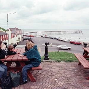 Families sitting on a bench looking at Saltburn pier, North Yorkshire. 9th May 1996