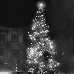 A family group admire the lit Christmas Tree in Church Street after a fresh fall of snow
