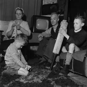 Family Life in Oldham 1952. Mother sews while father watch his youngest son play Family Life in Oldham 1952. Mother sews while father watch his youngest son play