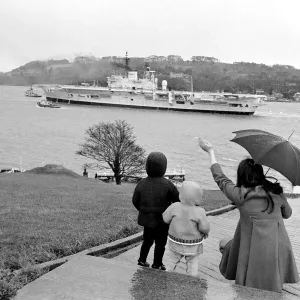 A family stand in the rain as they wave to Aircraft carrier HMS Ark Royal on preliminary A family stand in the rain as they wave to Aircraft carrier HMS Ark Royal on preliminary