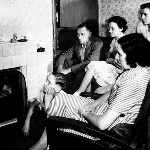 A family watch television together in their living room circa 1950