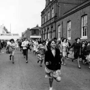 Fans of The Beatles, rush towards their car, outside thestudios of ABC TV in Birmingham