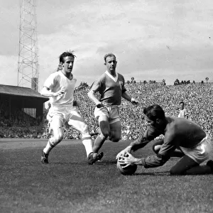Farm (Blackpool) goes down to beat Dennis Viollet to the ball watched by Garrett