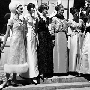 Fashion 1960s. Women gather in a group on the steps in street