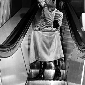 Fashion Coats Maxi January 1970 Woman on an escalator holding up her coat to show