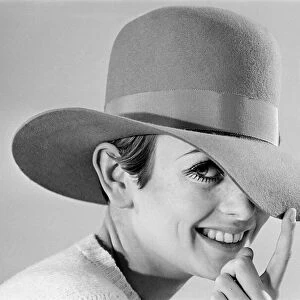 Fashion model Leslie Hornby, better known as Twiggy, modelling hats during a studio