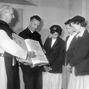 Father Celsus shows some visitors one of the monastery books at Mount Saint Bernard in