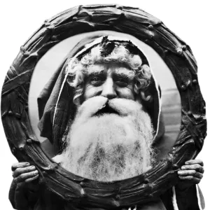 Father Christmas looking through a Holly Wreath. 12th December 1921 Father Christmas looking through a Holly Wreath. 12th December 1921
