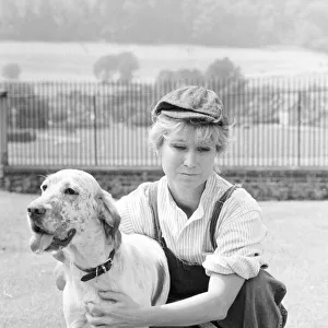 Felicity Kendal dressed as a gardener with a dog July 1982 whilst filming a new
