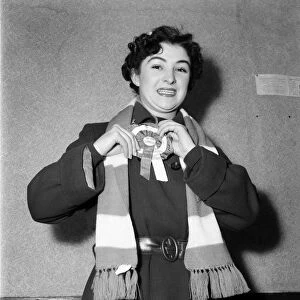 A female Arsenal fan showing of her rosette and scarf. February 1953 D697