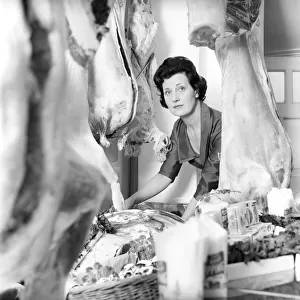 A female butcher seen here at work in her shop. 1963