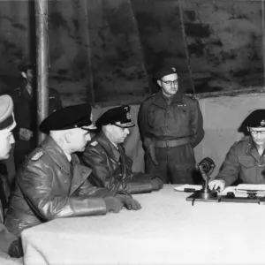 Field Marshal Montgomery (sitting right) reads over the surrender pact at his HQ at 21st Field Marshal Montgomery (sitting right) reads over the surrender pact at his HQ at 21st