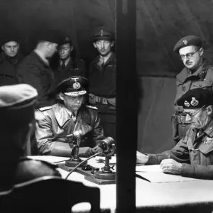 Field Marshal Montgomery (sitting right) reads over the surrender pact at his HQ at 21st Field Marshal Montgomery (sitting right) reads over the surrender pact at his HQ at 21st