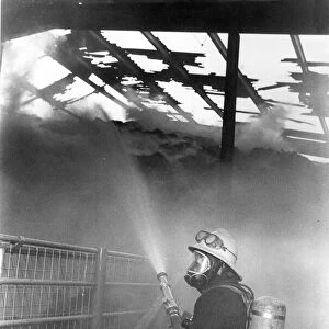 A firefighter fights the flames at a blaze at Hexham Auction Mart