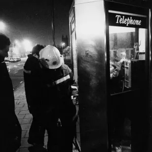 Firefighters free a youngter from a telephhone box jammed shut by his friends Firefighters free a youngter from a telephhone box jammed shut by his friends