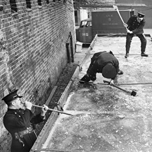 Fireman breaking down the ice at a Fire Station in world War Two. Possibly London