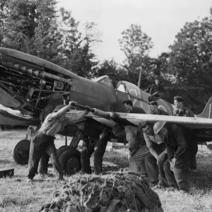 A black and white print of RAF mechanics servicing a Spitfire aircraft A black and white print of RAF mechanics servicing a Spitfire aircraft