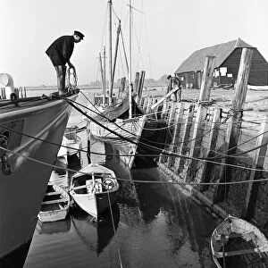 A fisherman mooring his boat at Bosham on the West Sussex Seafront. January 1953