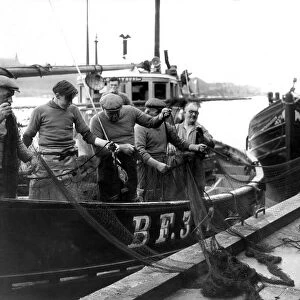 Fishermen of the Scottish herring boat Loranthus sort out their torn nets on North