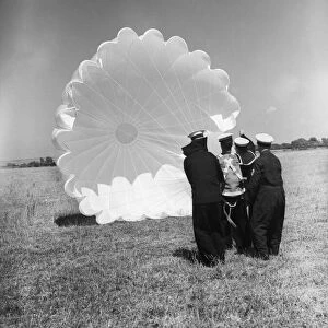 Fleet Air Arm parachute packers seen here testing a parachute at an un-named Royal Naval