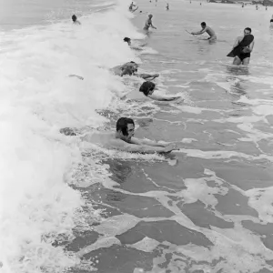 When the foaming waves break with a roar, bathers throw themselves forward onto their When the foaming waves break with a roar, bathers throw themselves forward onto their