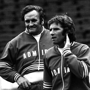 Football manager Don Revie with Alan Ball hand to ear wearing a track suit 1977