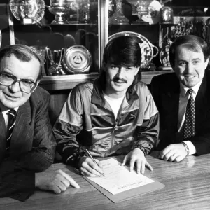 Footballer Ian Snodin pictured signing for Everton watched by manager Howard Kendall Footballer Ian Snodin pictured signing for Everton watched by manager Howard Kendall