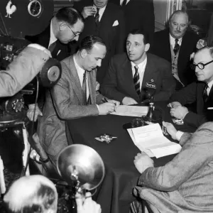 Footballer Tommy Lawton looks on as his new manager Jack Gibbons signs a contract after Footballer Tommy Lawton looks on as his new manager Jack Gibbons signs a contract after