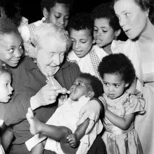 Print of Mrs. Ada Wheeler bottle feeding a foster child, July 1953 Print of Mrs. Ada Wheeler bottle feeding a foster child, July 1953