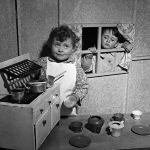 Four-year-old David McKnight and Jane Mathieson playing with their toy kitchen at