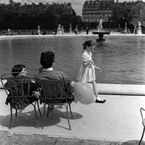 France Paris -A Mother and Daughter sit in a park by a fountain during the 1958 state of