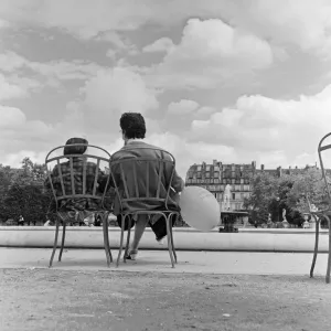 France Paris -A Mother and Daughter sit in a park by a fountain during the state of France Paris -A Mother and Daughter sit in a park by a fountain during the state of