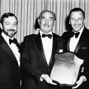 Frank Sinatra with friends holding a shield to tribute the Warner Brothers