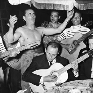 Frank Sinatra seen here playing the guitar during a gala party held by Grace Kelly in