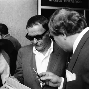 Frank Sinatra, signant des autographes à l'extérieur du Royal Festival Hall, Londres. Frank Sinatra, signant des autographes à l'extérieur du Royal Festival Hall, Londres.