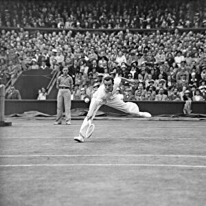 Fred Perry (GB) plays a back hand shot at the net, competing at the Wimbledon Tennis Mens