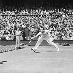 Fred Perry (GB) plays a back hand shot at the net, competing at Wimbledon Tennis in