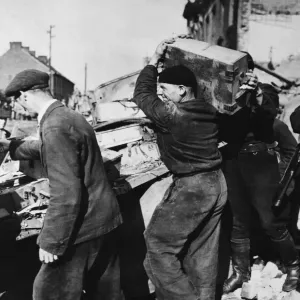 Free French Infantry carry off arms and ammunition from a knocked out German truck Free French Infantry carry off arms and ammunition from a knocked out German truck