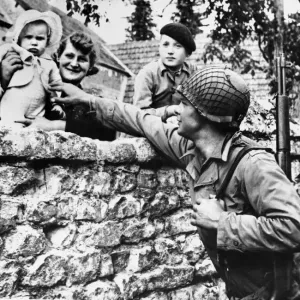 French civilians lean over their garden wall to greet an american solider of the allied French civilians lean over their garden wall to greet an american solider of the allied