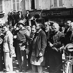 French civilians stand at attention and an American Army Gl salutes as the American