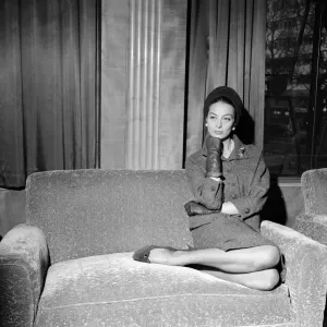 La actriz francesa de cine Capucine se sienta en un sofá en el Odeón de Leicester Square.