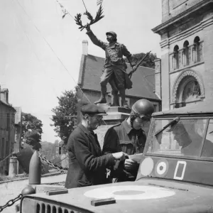 A French villager assists RAF traffic control at a Normandy road junction